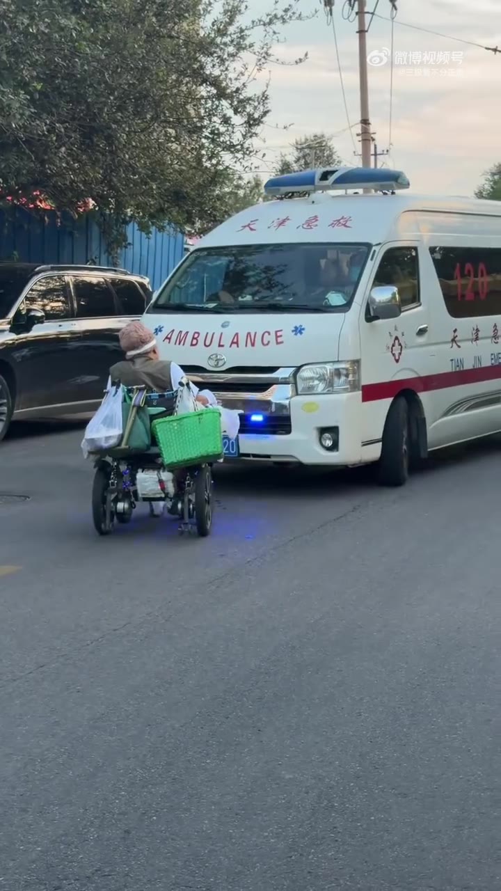 天津街头，一辆正在执行急救任务、鸣笛示警的救护车正常行驶途中，一名乘坐轮椅的大妈刻意拦在车辆前方，迟迟不肯挪开，硬生生挡住了救护车前进路线。 现场医护人员不断…
